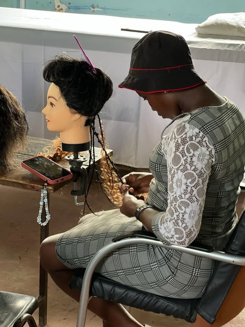 Person wearing plaid suit and black hat examining a mannequin head display in a museum or exhibition space